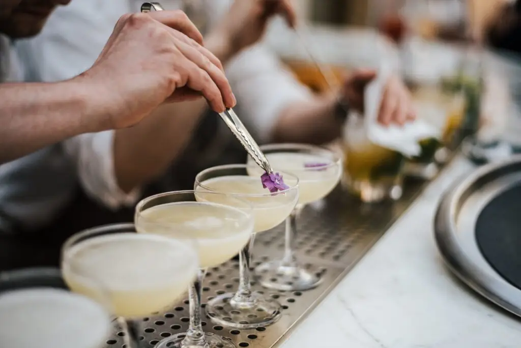 Copas reutilizables para cócteles en una barra de coctelería con bebidas coloridas y presentación cuidada.